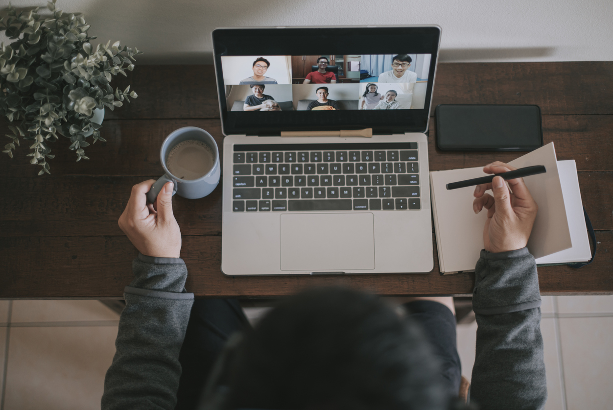 An asian chinese male working at home using laptop video conference call meeting